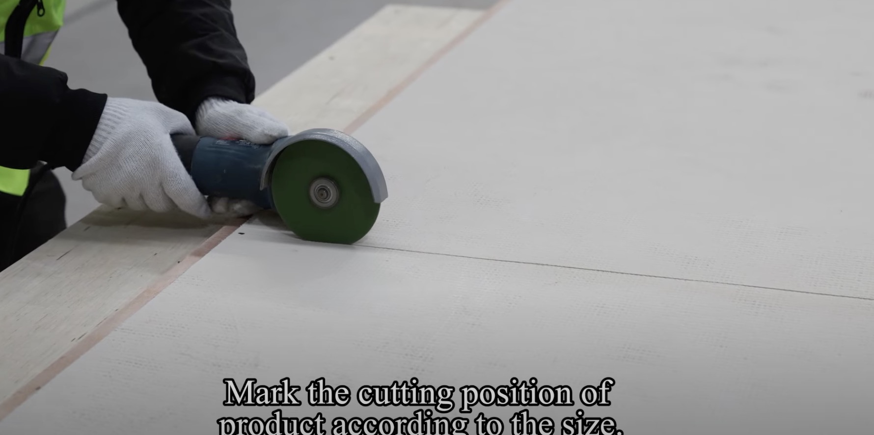 Installer applying adhesive to a wall before fixing flexible stone veneer panels, keeping the movement joint clear