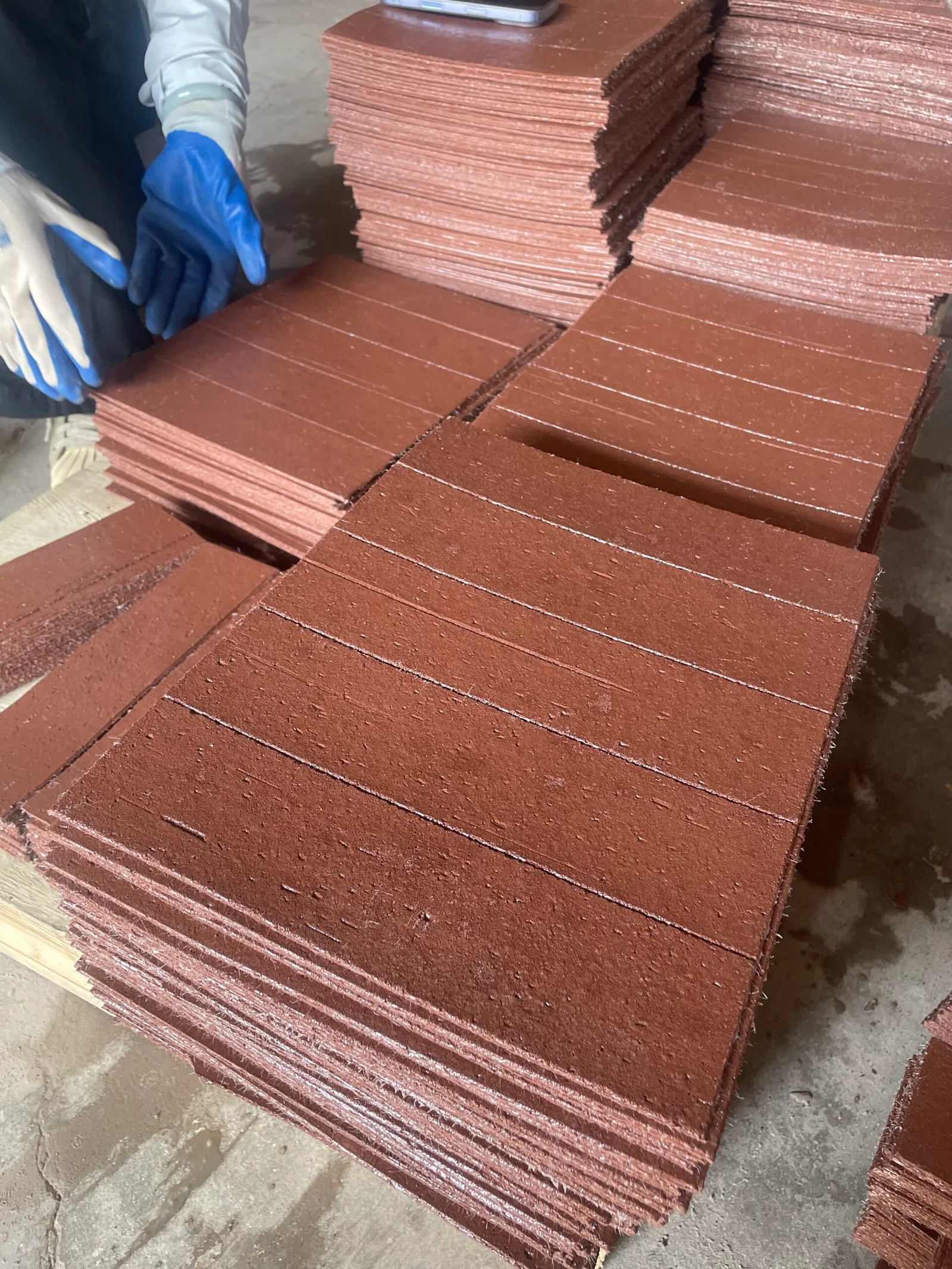 Stacks of flexible brick veneer sheets with fiberglass backing visible, the material a COA describes but does not itself inspect