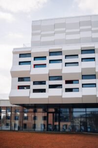 ein hohes weißes Gebäude mit vielen Fenstern an der Seite